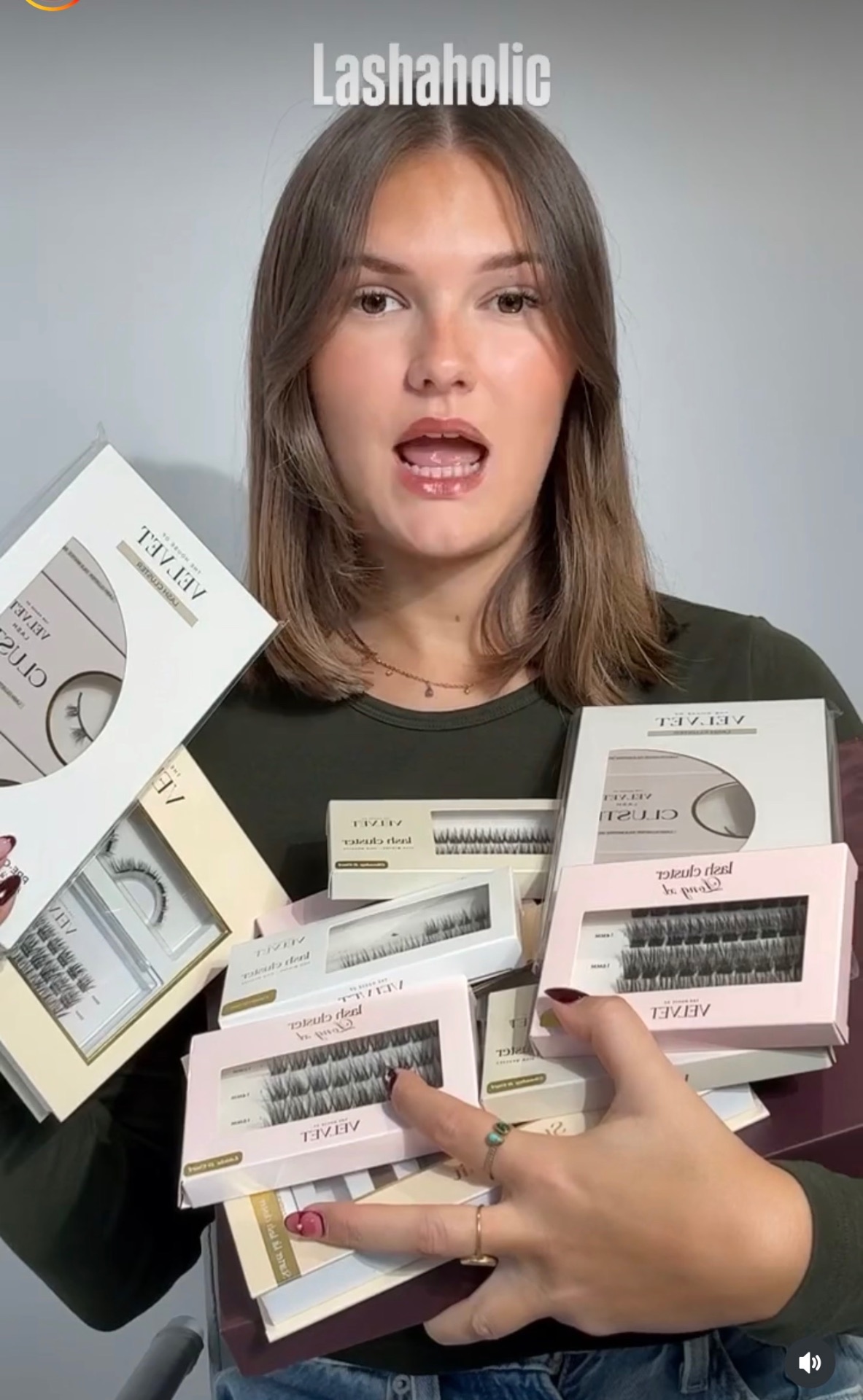 Une femme tenant plusieurs boîtes de cils cluster Velvet